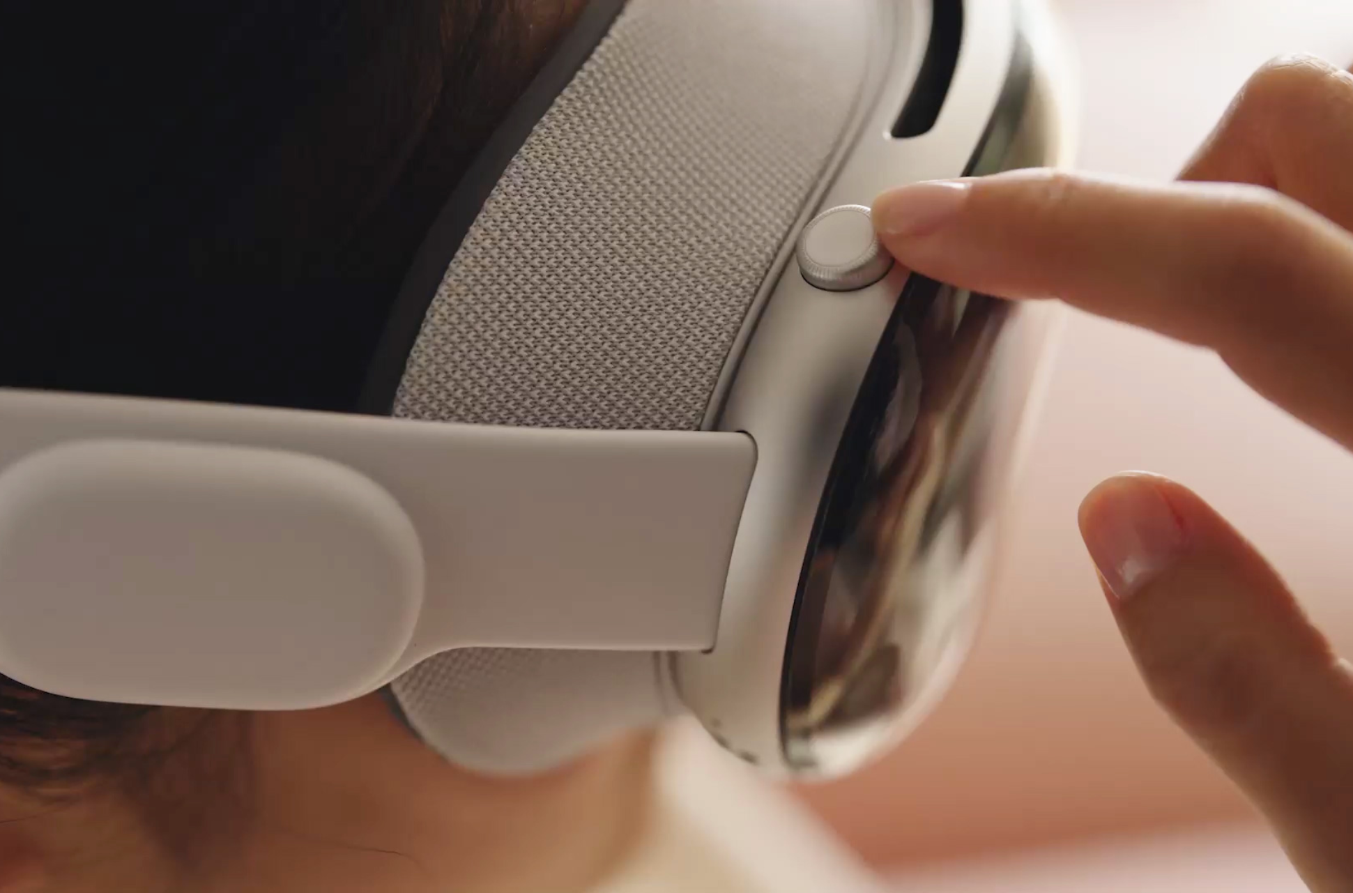 Apple Vision Pro in Weiß mit Digital Crown und einer Hand